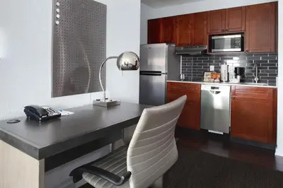 a kitchen with a desk and a white chair at Hyatt House Branchburg - Bridgewater in Branchburg Park