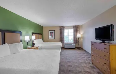 a hotel room with two beds and a flat screen tv at Extended Stay America Suites - Newark - Woodbridge in Woodbridge