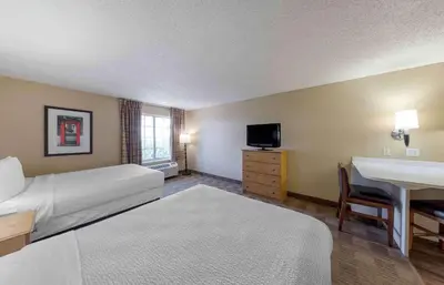 a hotel room with a bed and a sink and a desk at Extended Stay America Suites - Newark - Woodbridge in Woodbridge