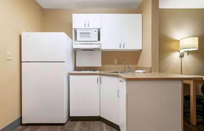 a kitchen with white cabinets and a white refrigerator at Extended Stay America Suites - Newark - Woodbridge in Woodbridge
