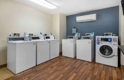 a row of washing machines and a washer and dryer at Extended Stay America Suites - Newark - Woodbridge in Woodbridge