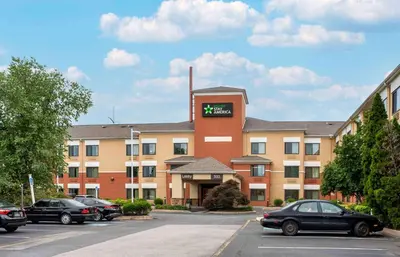 a hotel with cars parked in a parking lot at Extended Stay America Suites - Newark - Christiana - Wilmington in Rutherford