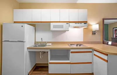 a kitchen with white cabinets and a sink and a refrigerator at Extended Stay America Suites - Newark - Christiana - Wilmington in Rutherford