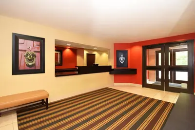 a waiting room with red walls and a mirror at Extended Stay America Suites - Newark - Christiana - Wilmington in Rutherford