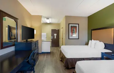 a hotel room with two beds and a flat screen tv at Extended Stay America Suites - Philadelphia - Airport - Tinicum Blvd in Philadelphia