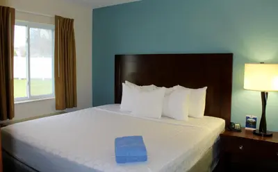 a bedroom with a bed with a blue towel on it at Canyon Motel in Wellsboro