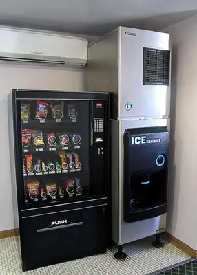 a ice cream vending machine next to a refrigerator at Canyon Motel in Wellsboro