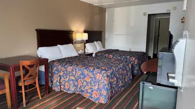 a hotel room with two beds and a desk at Rodeway Inn Dunmore in Dunmore