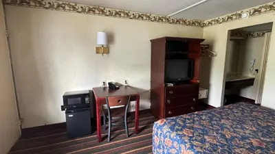 a hotel room with a bed and a sink and a television at Rodeway Inn Dunmore in Dunmore