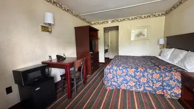 a hotel room with a bed and a desk at Rodeway Inn Dunmore in Dunmore