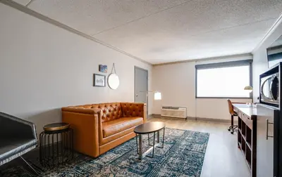 a living room with a leather couch and a table at Four Points by Sheraton York in York