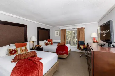 a hotel room with two beds and a flat screen tv at Brandywine River Hotel in Chadds Ford
