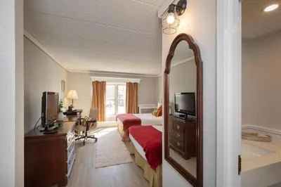 a hotel room with a bed and a mirror at Brandywine River Hotel in Chadds Ford