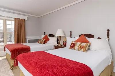 two beds in a room with a red blanket at Brandywine River Hotel in Chadds Ford