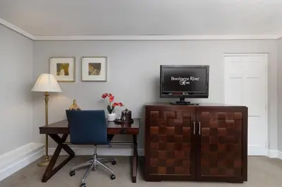 a room with a desk and a television and a chair at Brandywine River Hotel in Chadds Ford