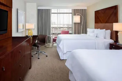 a hotel room with two beds and a television at The Westin Mount Laurel in Mount Laurel