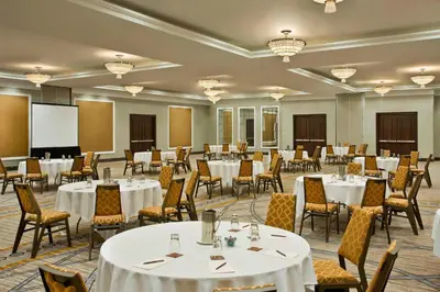 a conference room with tables and chairs and a screen at Sheraton Valley Forge King of Prussia in King of Prussia