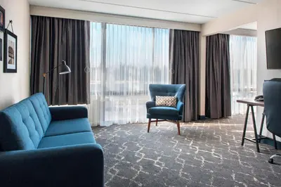 a living room with a blue couch and a chair at Four Points Philadelphia Northeast in Philadelphia
