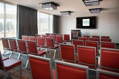 a conference room with red chairs and a tv at Four Points Philadelphia Northeast in Philadelphia
