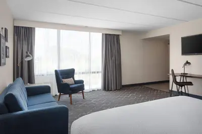 a hotel room with a bed and a chair at Four Points Philadelphia Northeast in Philadelphia