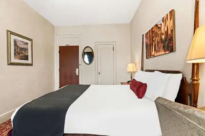 a bedroom with a large white bed and a couch at Genetti Hotel, SureStay Collection by Best Western in Williamsport
