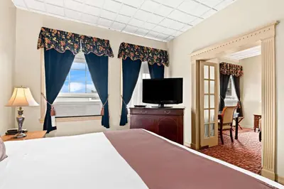 a bedroom with a bed and a tv and a window at Genetti Hotel, SureStay Collection by Best Western in Williamsport