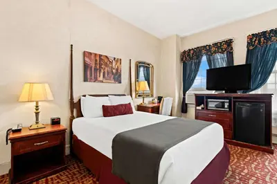 a hotel room with a bed and a flat screen tv at Genetti Hotel, SureStay Collection by Best Western in Williamsport