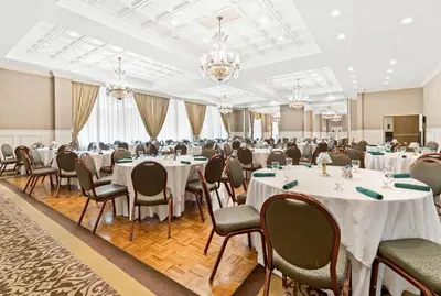 a banquet hall with tables and chairs and chandeliers at Genetti Hotel, SureStay Collection by Best Western in Williamsport