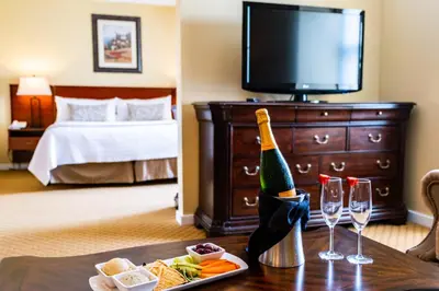 a hotel room with a table with a bottle of champagne and wine glasses at Nassau Inn in Princeton