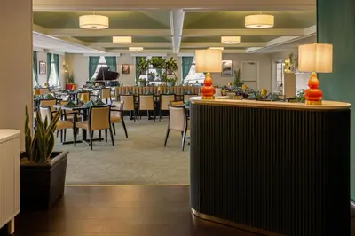 a restaurant with tables and chairs in a room at Penn Harris Hotel Harrisburg, Trademark by Wyndham in Harrisburg