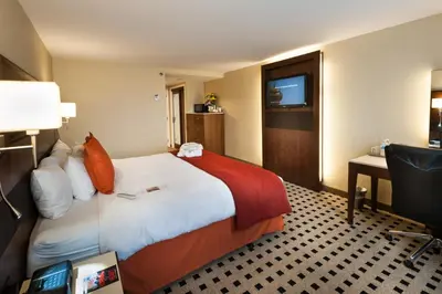 a hotel room with a bed and a desk at Penn Harris Hotel Harrisburg, Trademark by Wyndham in Harrisburg