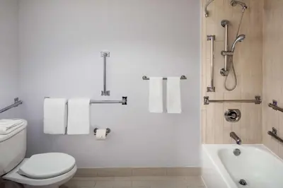 a bathroom with a toilet and a bath tub with towels at Hyatt Regency Morristown in Morristown