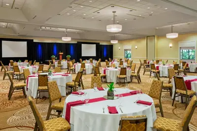 a banquet hall with white tables and chairs at Sheraton Harrisburg Hershey Hotel in Harrisburg