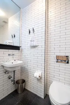 a white bathroom with a toilet and a sink at Pod 39 in New York