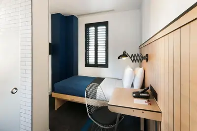 a small bedroom with a bed and a desk at Pod 39 in New York