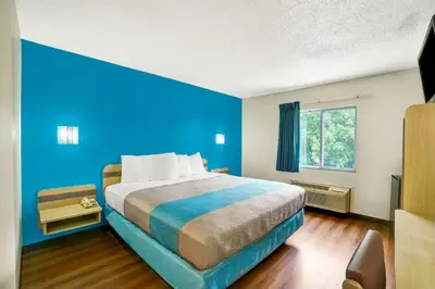 a blue bedroom with a bed and a window at Motel 6-Gordonville, PA - Lancaster PA in Gordonville