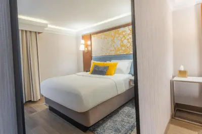 a bedroom with a bed with yellow pillows and a mirror at The Westfield Inn, BW Signature Collection in Westfield