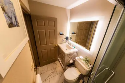 a bathroom with a toilet and a sink and a mirror at The Westfield Inn, BW Signature Collection in Westfield