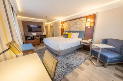 a hotel room with a large bed and a chair at The Westfield Inn, BW Signature Collection in Westfield