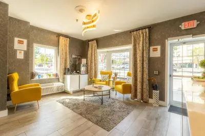 a living room with yellow chairs and a table at The Westfield Inn, BW Signature Collection in Westfield