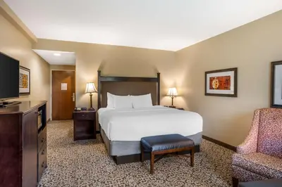 a hotel room with a bed and a chair at Best Western Plus Intercourse Village Inn in Intercourse