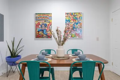 a dining room table with chairs and a vase on it at The Cherry Suites - Chinatown in Philadelphia