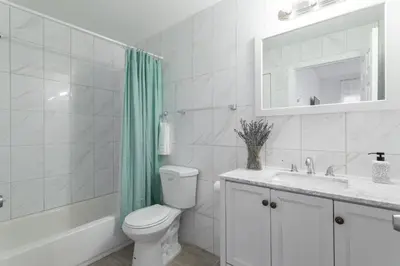 a bathroom with a toilet and a sink and a mirror at The Cherry Suites - Chinatown in Philadelphia