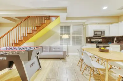 a living room with a ping pong table and a kitchen at The Cherry Suites - Chinatown in Philadelphia