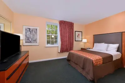 a hotel room with a bed and a flat screen tv at Media Inn & Suites in Media