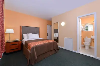 a hotel room with a bed and a toilet at Media Inn & Suites in Media