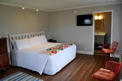 a bedroom with a bed and two chairs and a television at Silver Birches Resort in Hawley