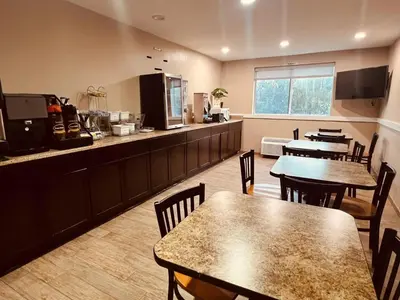 a restaurant with tables and a kitchen with a counter at FairBridge Inn Express Nyack in Nyack