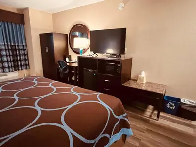 a hotel room with a bed and a desk and a mirror at FairBridge Inn Express Nyack in Nyack