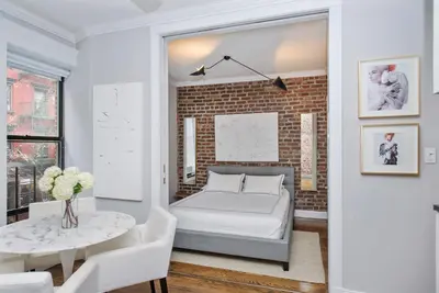 a bedroom with a bed and a brick wall at APARTMENT NOLITA in New York